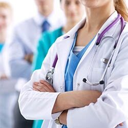 Several doctors in lab coats and scrubs with stethoscopes